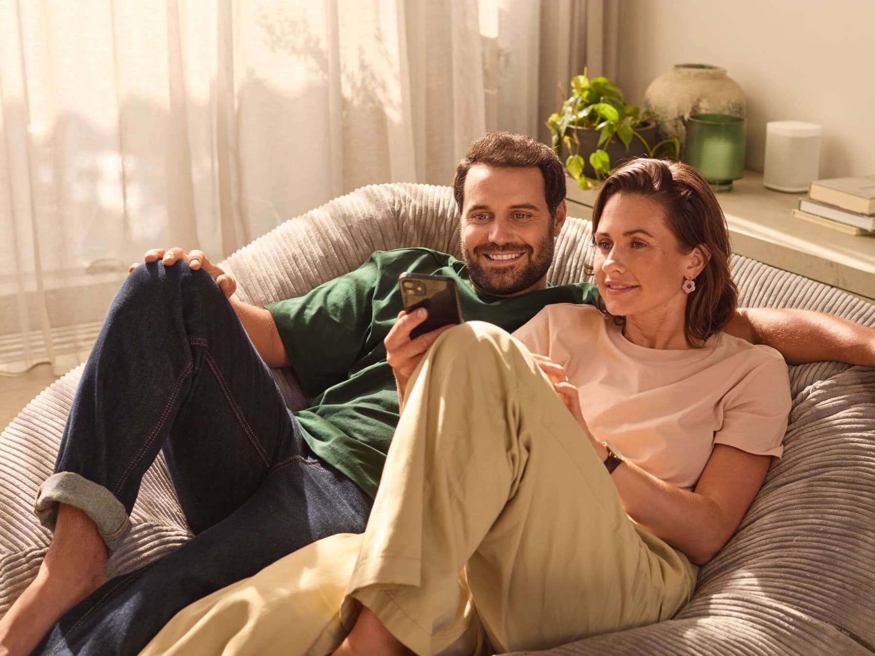 Casal no sofá a olhar para o telemóvel