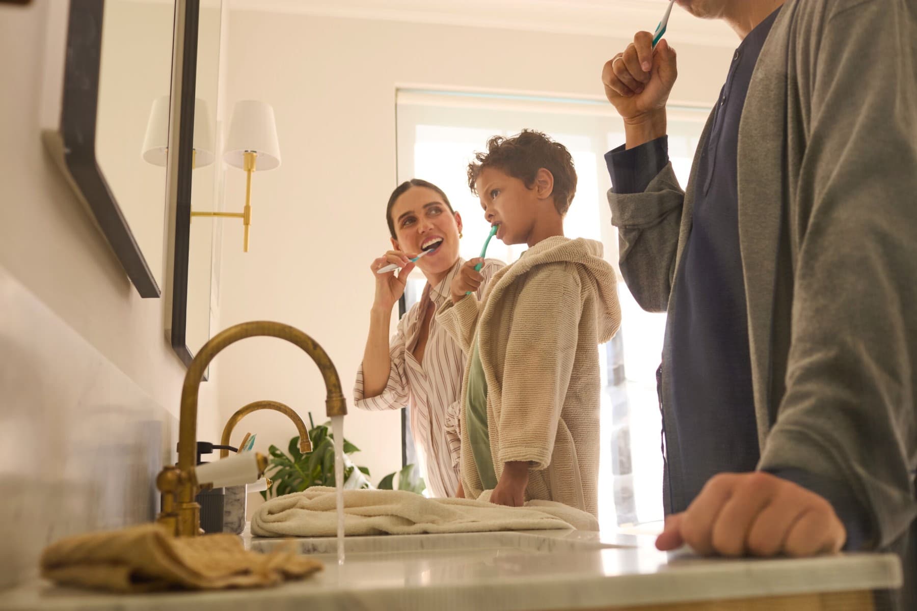 uma família está a escovar os dentes na casa de banho