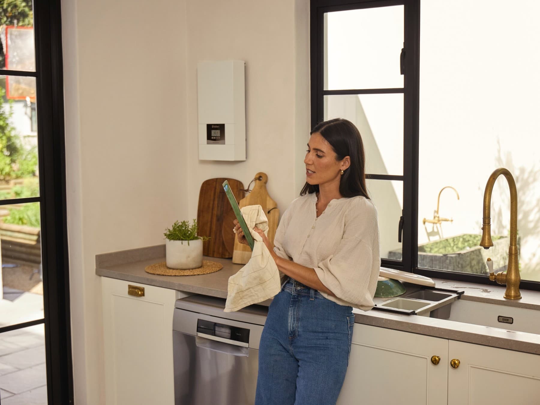 Mulher a lavar pratos na cozinha