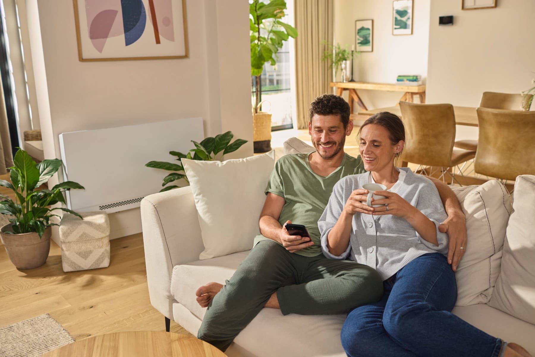 Casal sentado no sofá a olhar para um smartphone