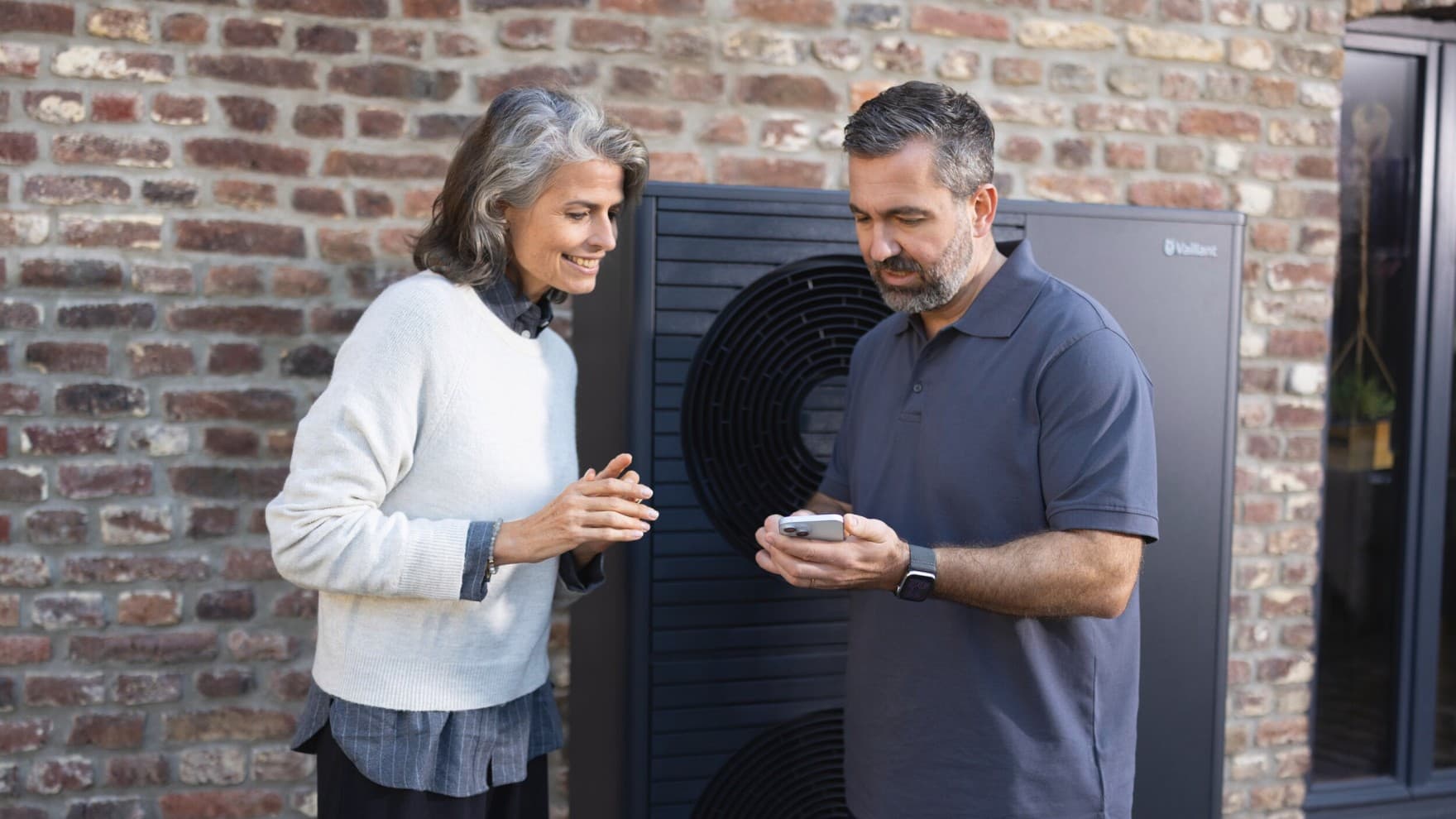 O instalador explica a aplicação myVaillant à mulher.