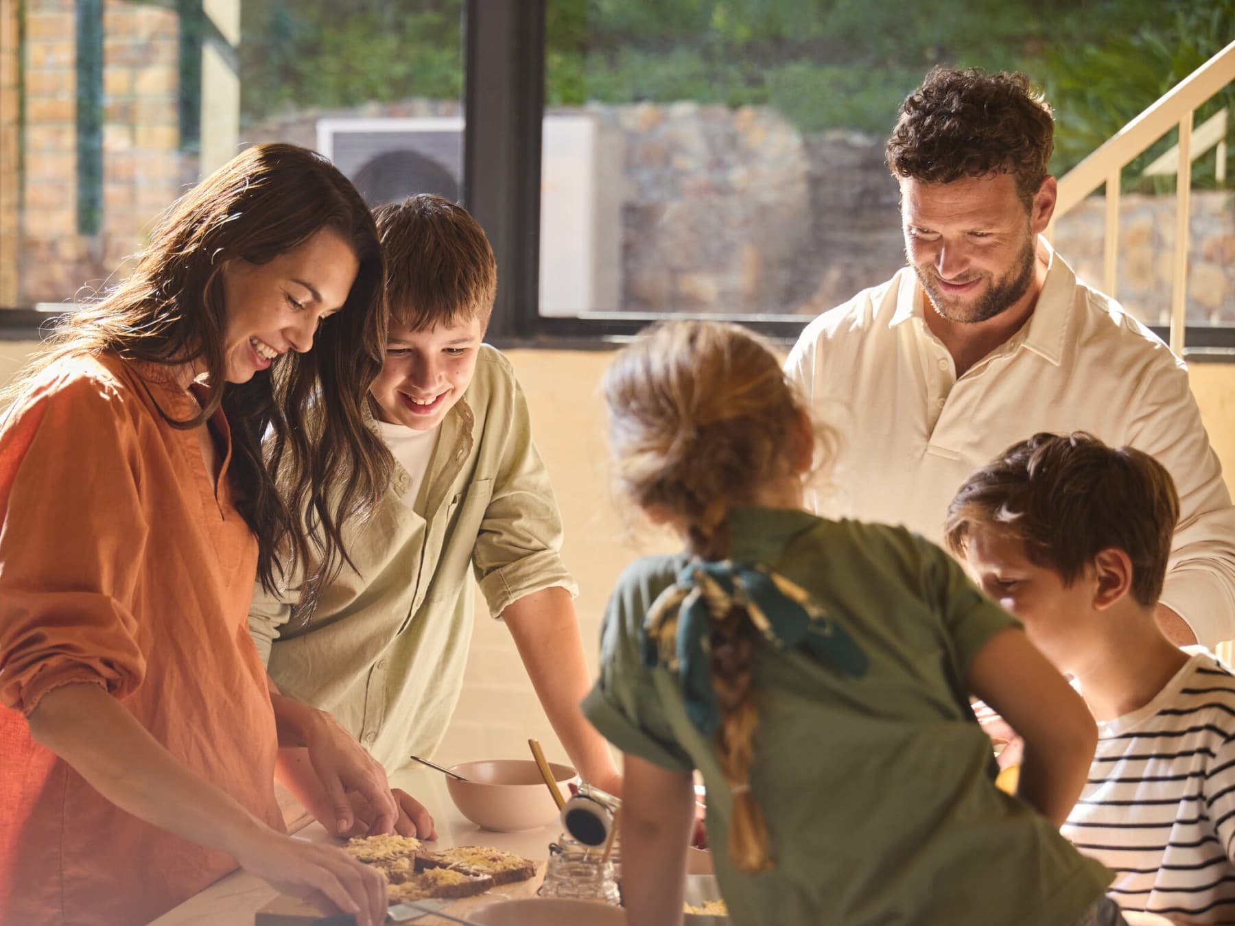 Uma família a cortar um bolo na cozinha
