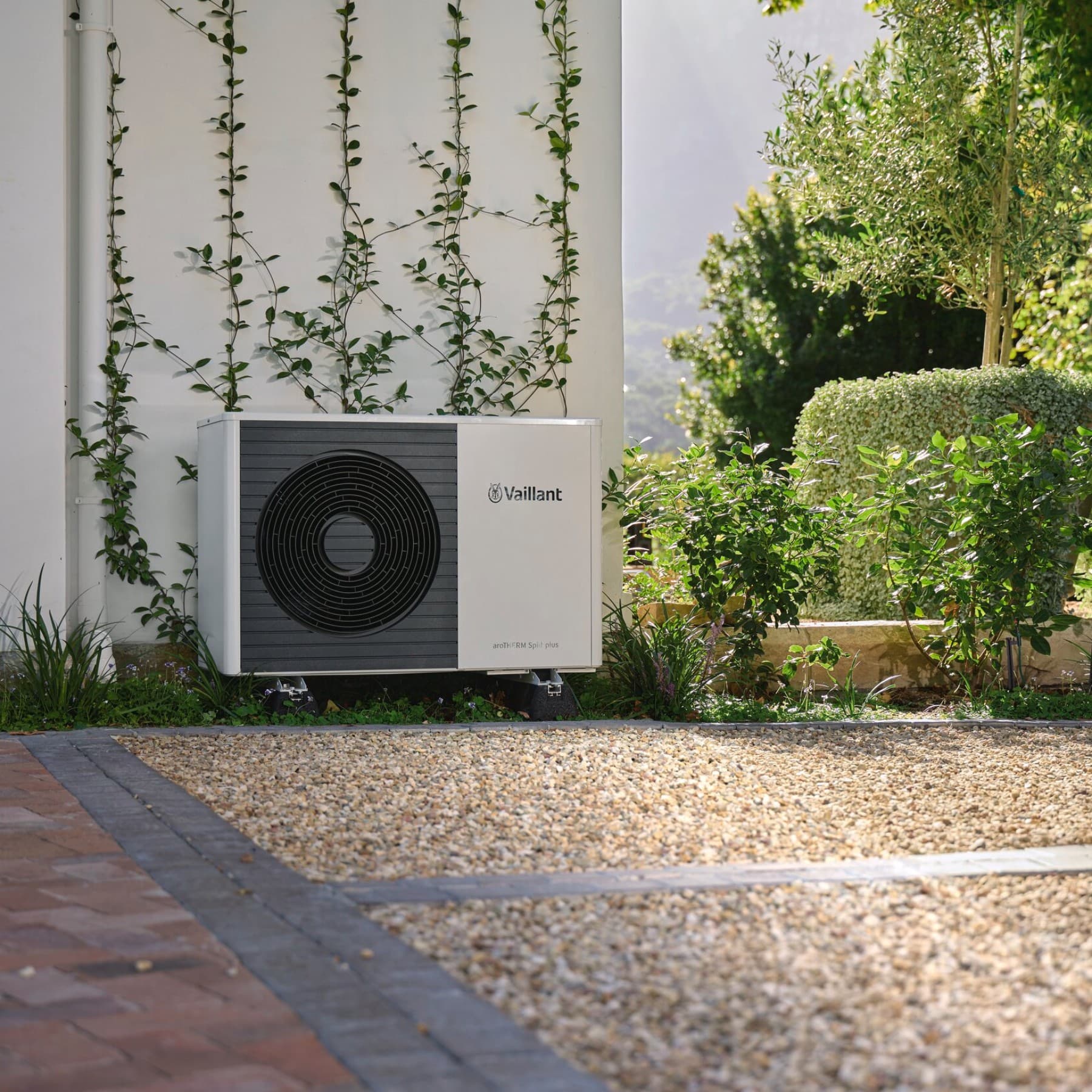 Bomba de calor Vaillant colocada em frente a uma parede num jardim