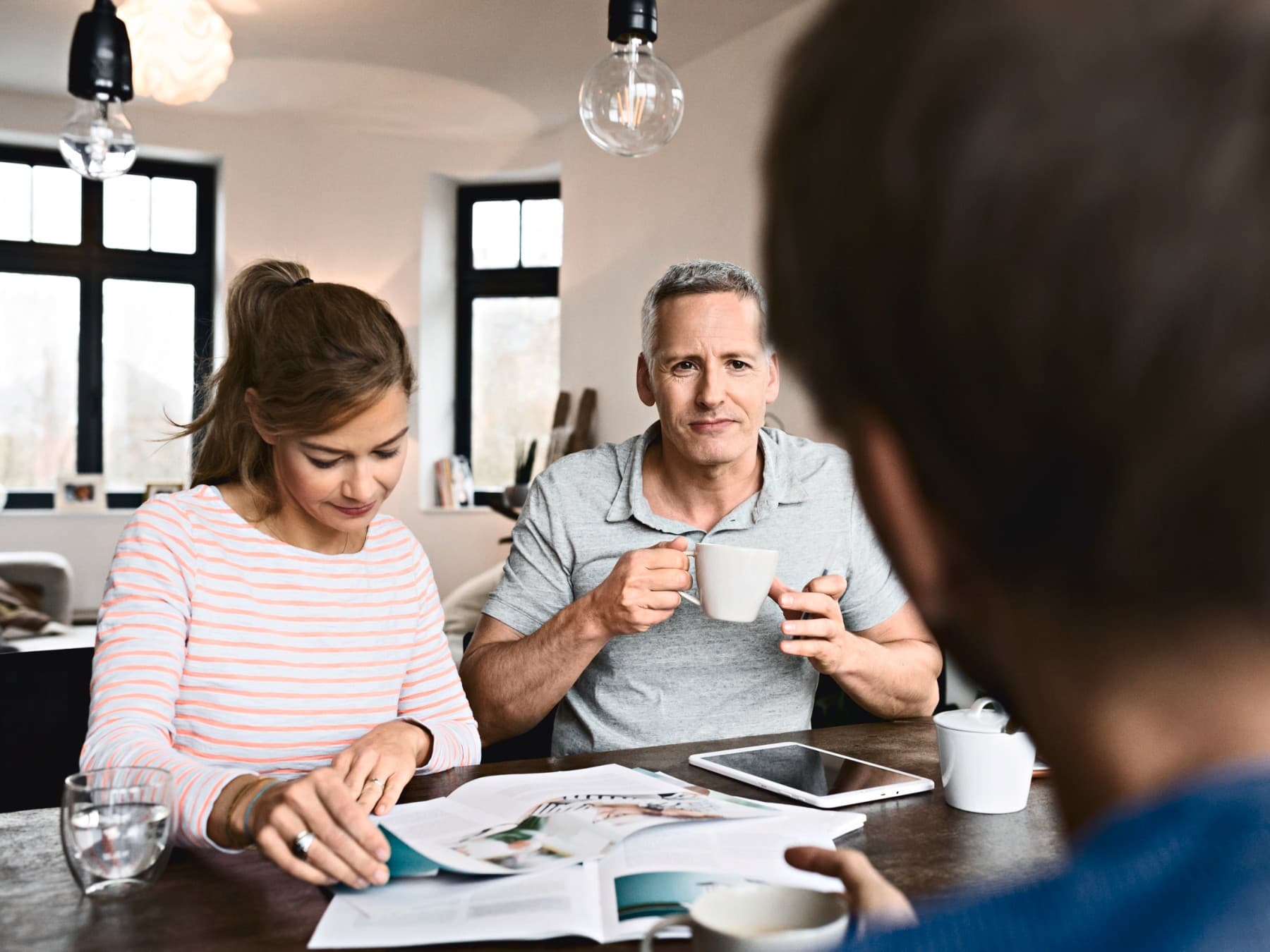 amigos sentados juntos a conversar e a folhear catálogos da Vaillant