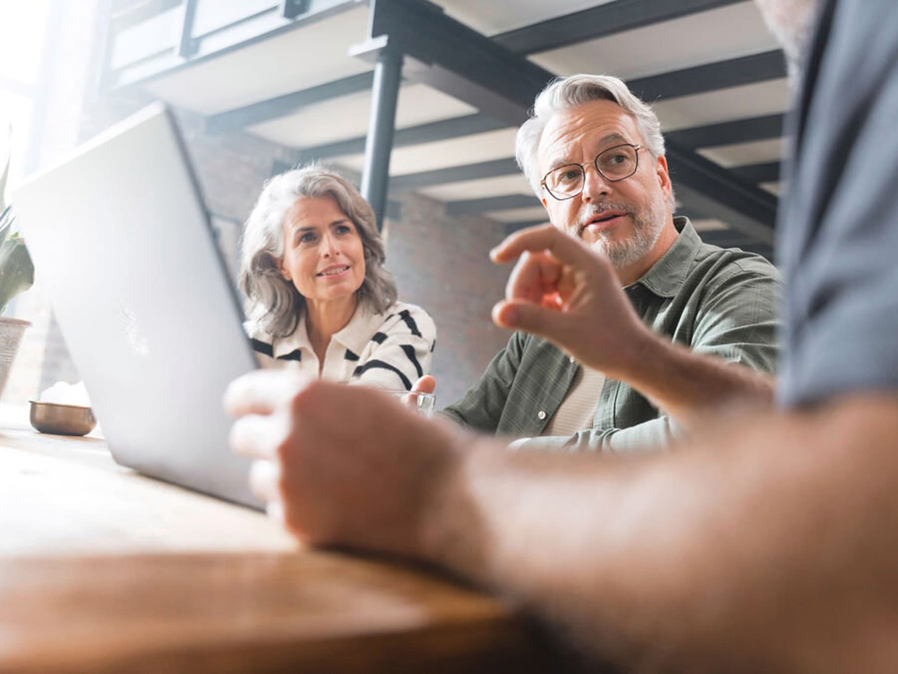 Situação de aconselhamento sobre caldeiras em casa - casal sentado numa mesa a discutir com um instalador